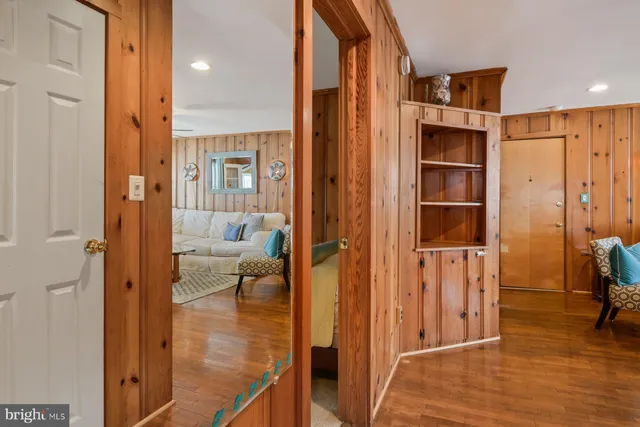 a view of a hallway with wooden floor windows and a livingroom