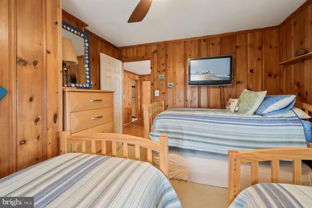 a bedroom with a bed a dresser and a window