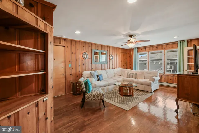a living room with furniture a ceiling fan and a window