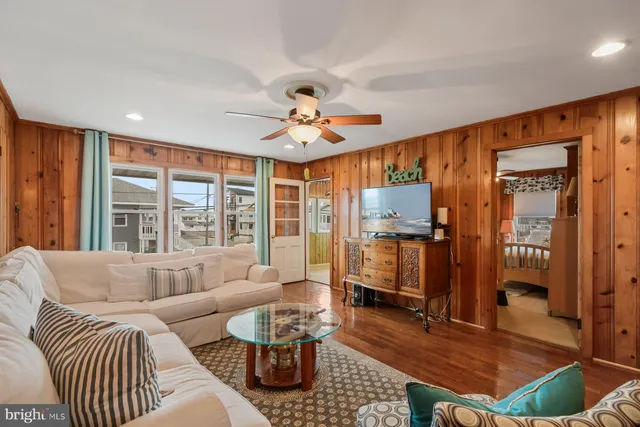 a living room with furniture a ceiling fan and a window