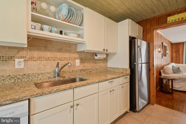 a kitchen with stainless steel appliances granite countertop a refrigerator and a sink