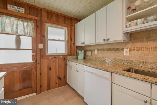 a kitchen with a sink window and cabinets