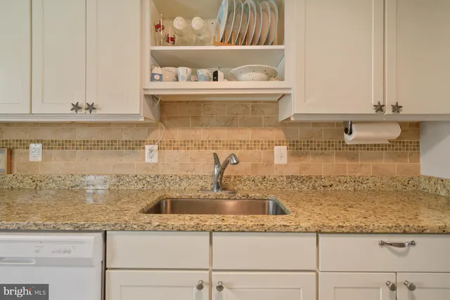 a kitchen with granite countertop a sink and cabinets