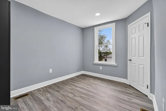 a view of a big room with wooden floor and windows