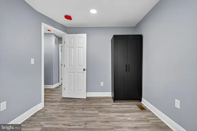 an empty room with wooden floor and closet