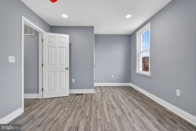 a view of an empty room with wooden floor