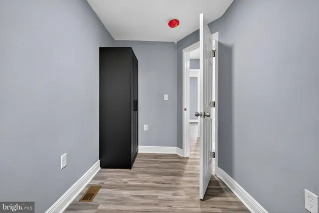 a view of a hallway with wooden floor and closet