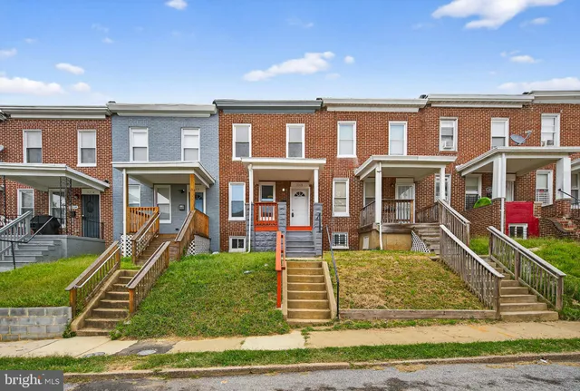 a front view of a residential apartment building with a yard