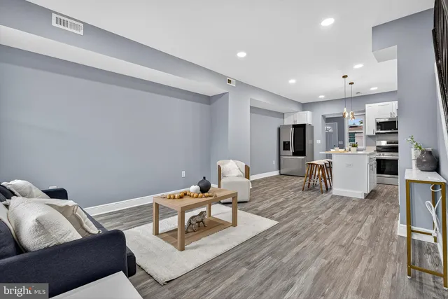 a living room with furniture and kitchen view