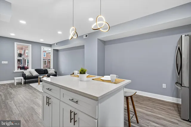 a view of kitchen island wooden floor and white cabinets