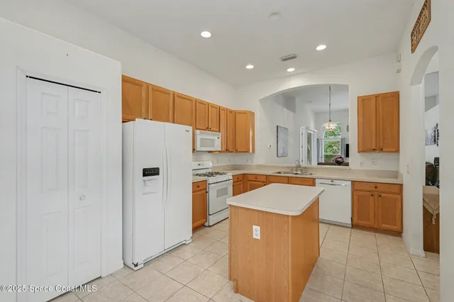 a kitchen with granite countertop a sink and a refrigerator