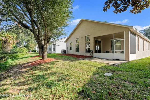 a view of a house with backyard and tree