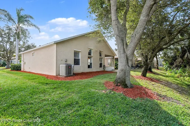 a white house that has tree in front of it