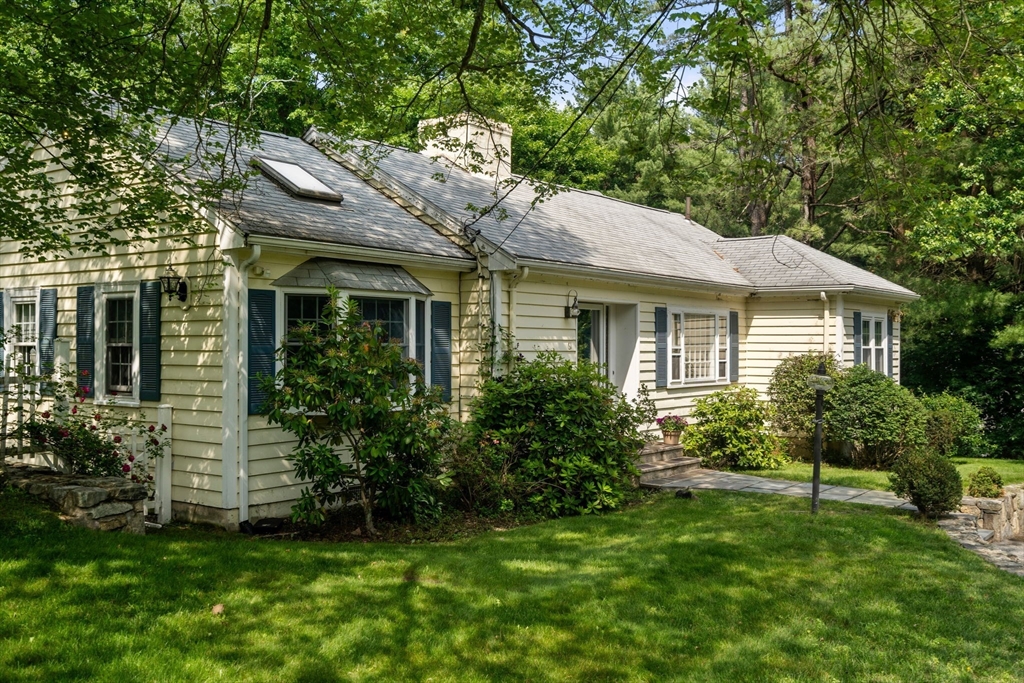 61 Conant Road Westwood, MA 02090 - Photo 5 of 12 a view of a house with brick walls and a yard with plants