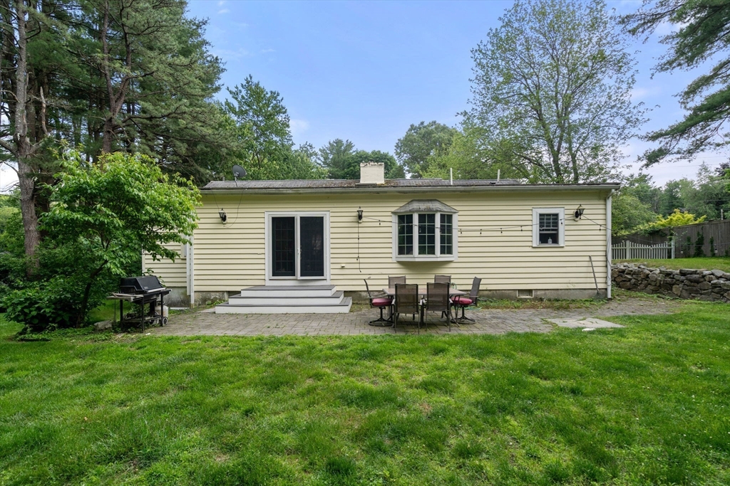 61 Conant Road Westwood, MA 02090 - Photo 9 of 12 a view of a backyard with table and chairs and wooden fence