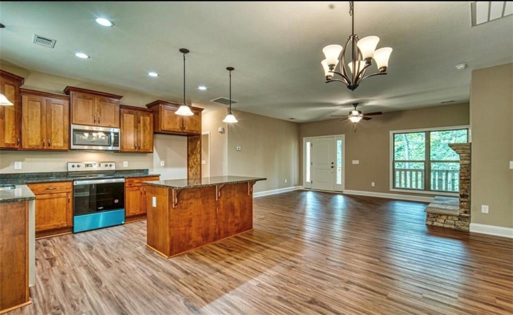 199 Lola Mae Way Morganton, GA 30560 - Photo 11 of 39 a large kitchen with stainless steel appliances granite countertop a stove oven a large island with wooden floor and cabinets
