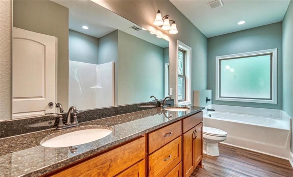 199 Lola Mae Way Morganton, GA 30560 - Photo 16 of 39 a bathroom with a granite countertop double vanity sink a mirror and a bathtub