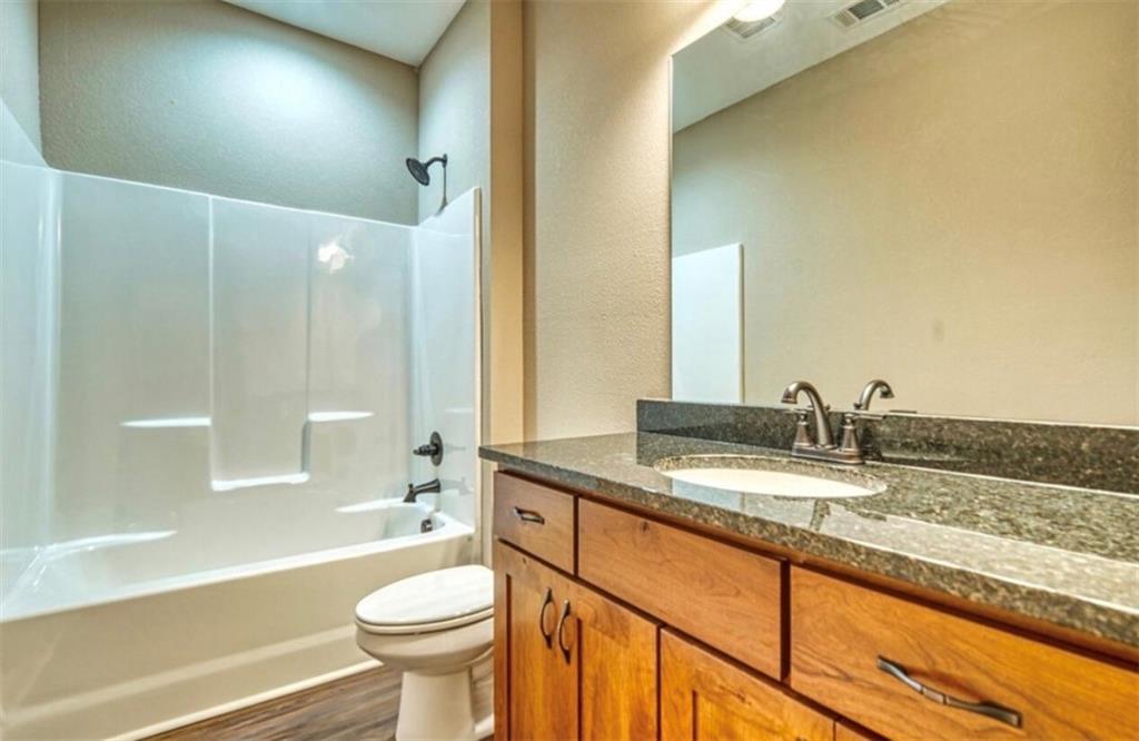 199 Lola Mae Way Morganton, GA 30560 - Photo 22 of 39 a bathroom with a granite countertop sink toilet mirror and a bathtub