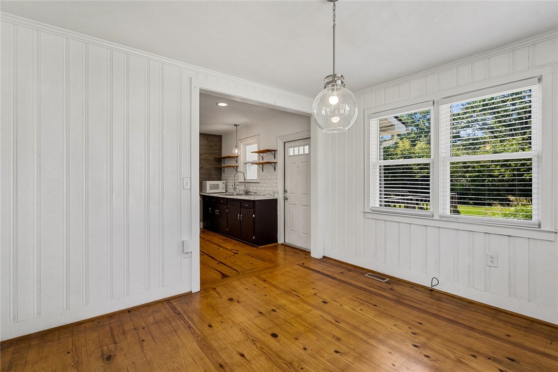419 Whitehall Road Anderson, SC 29625 - Photo 9 of 28 Natural wood floors extend throughout this luminous space, complemented by a contemporary pendant light fixture.