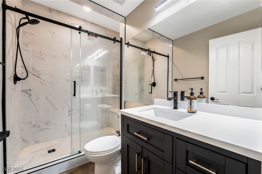 2392 Rainswept Avenue Henderson, NV 89052 - Photo 33 of 49 Full bath featuring a baseboard heating unit, vanity, a marble finish shower, and toilet