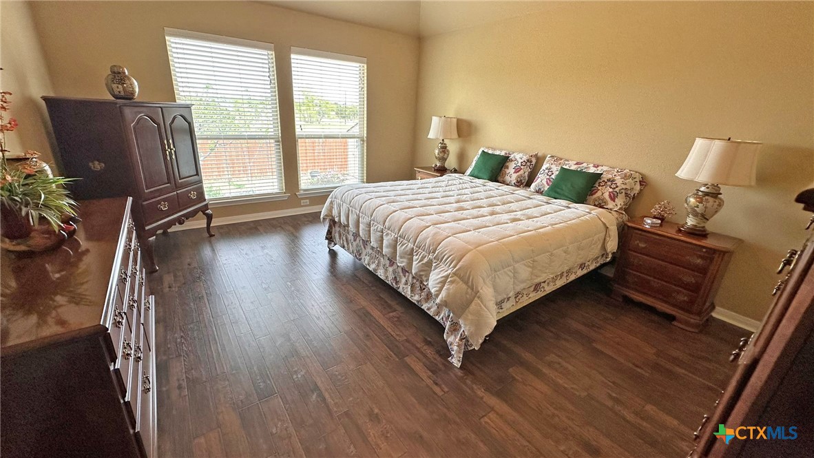 4709 Farrell Lane Killeen, TX 76549 - Photo 14 of 30 a bedroom with a bed painting and wooden floor