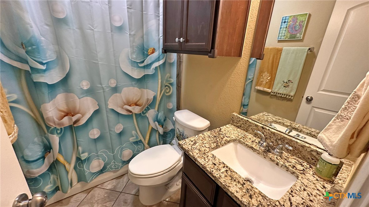 4709 Farrell Lane Killeen, TX 76549 - Photo 24 of 30 a bathroom with a granite countertop toilet sink and mirror