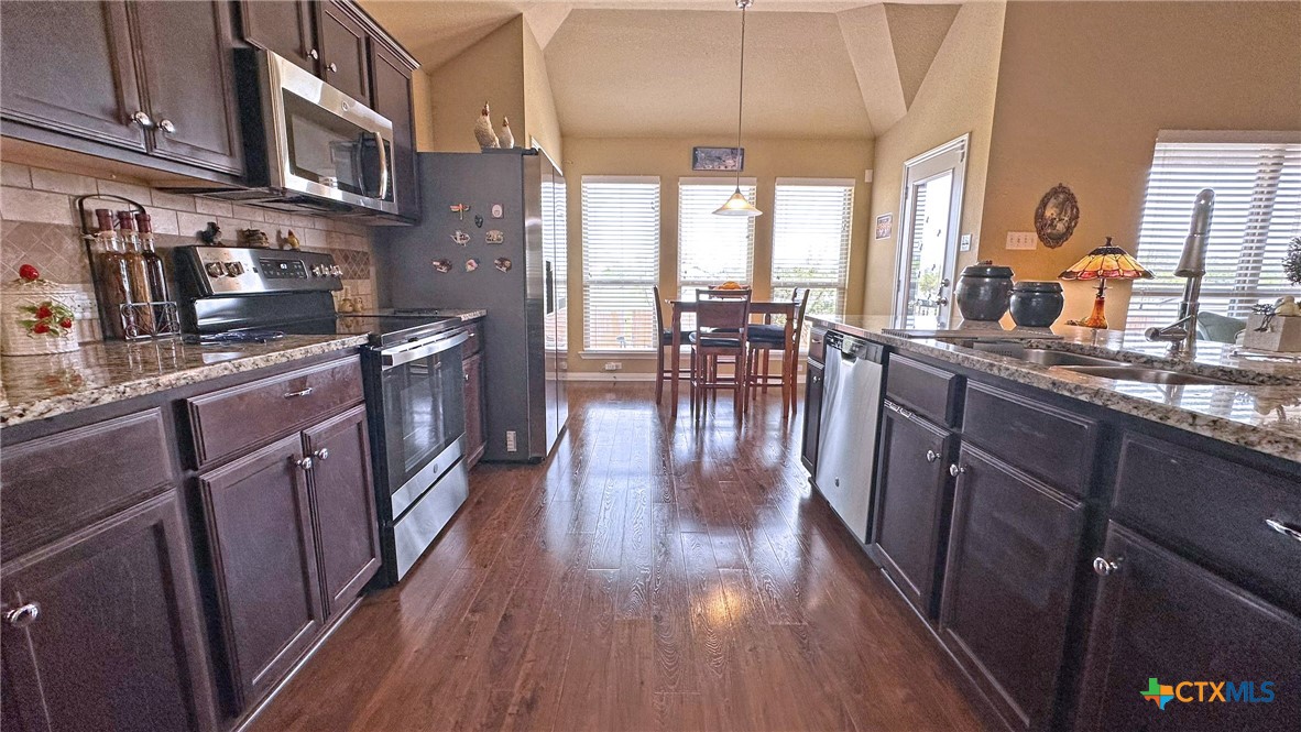 4709 Farrell Lane Killeen, TX 76549 - Photo 10 of 30 a kitchen with stainless steel appliances granite countertop wooden floors and wooden cabinets