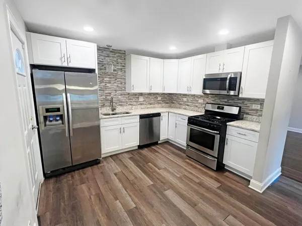 a kitchen with stainless steel appliances a refrigerator sink and microwave