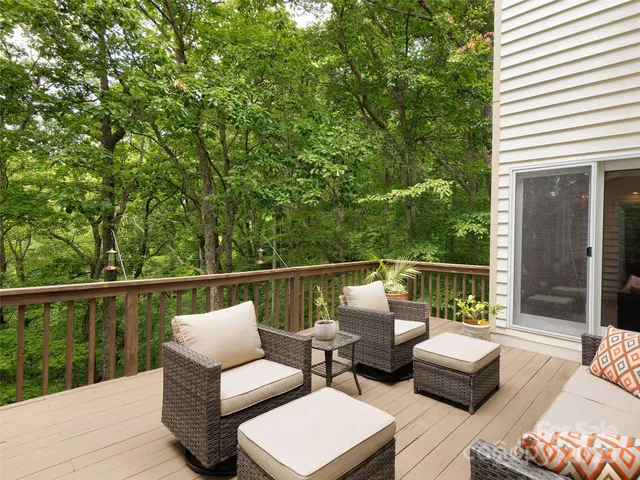 a balcony with wooden floor and outdoor seating