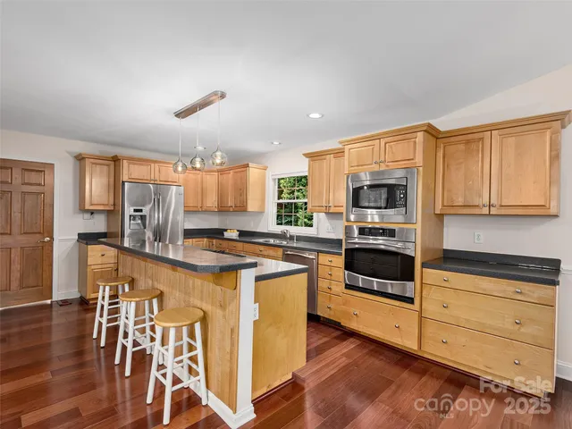 a kitchen with stainless steel appliances a stove a sink dishwasher and a refrigerator