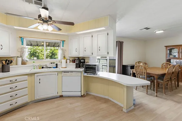a kitchen with stainless steel appliances kitchen island granite countertop a table chairs and a window