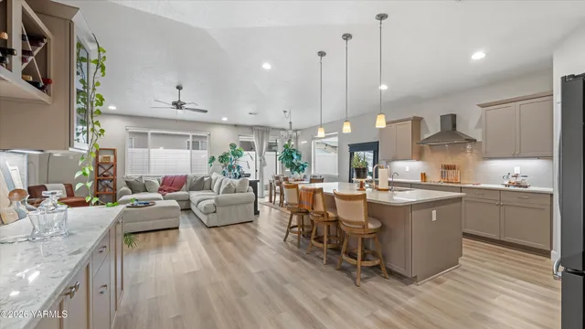 a large kitchen with kitchen island a sink a center island stainless steel appliances and a dining table view living room
