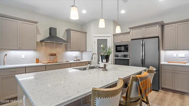 a kitchen with stainless steel appliances granite countertop a sink refrigerator and cabinets