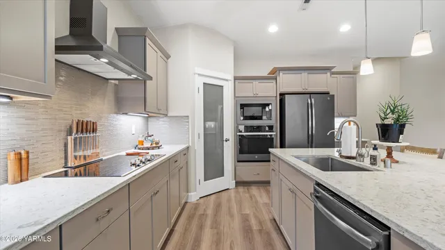 a kitchen with stainless steel appliances granite countertop a sink refrigerator and cabinets