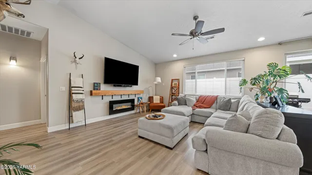 a living room with furniture a fireplace and a flat screen tv