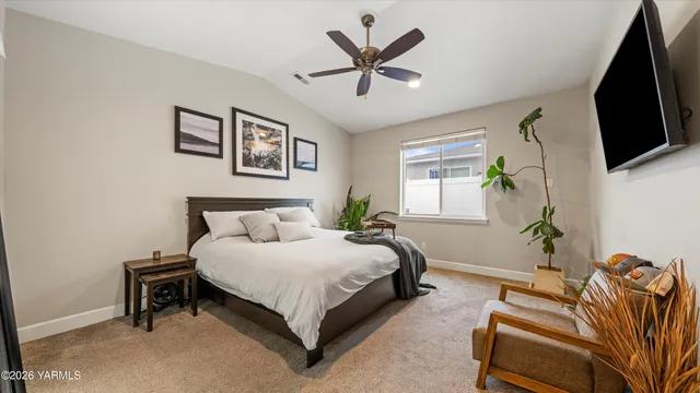 a spacious bedroom with a bed and a flat screen tv