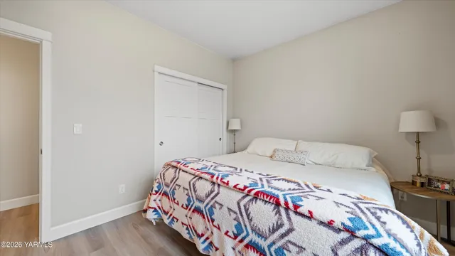 a bedroom with a bed and a lamp on the dresser