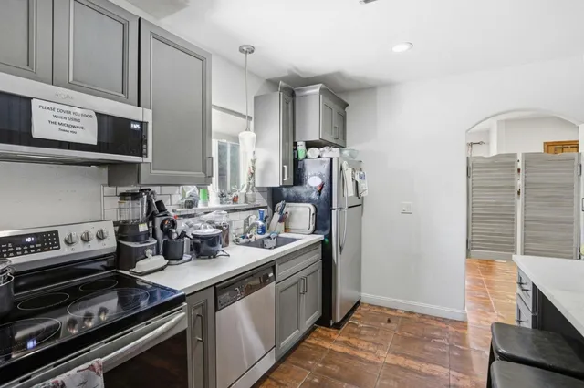 a kitchen with stainless steel appliances kitchen island granite countertop a sink and cabinets