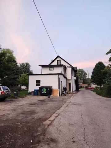 a view of a house with a big yard and large trees