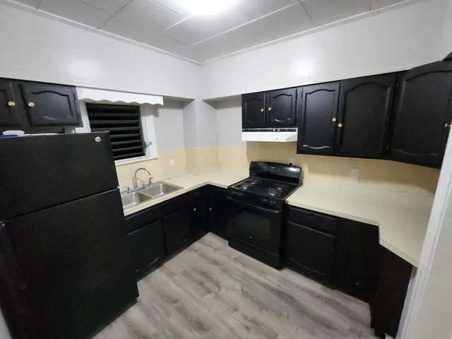 a kitchen with a refrigerator and a stove top oven