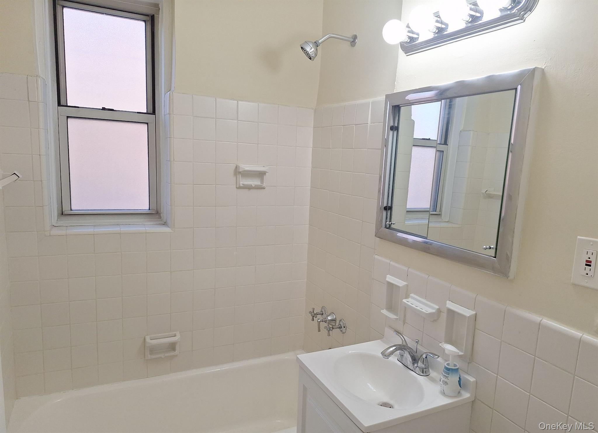 3475 Greystone Avenue, Unit 7E Bronx, NY 10463 - Photo 3 of 12 a bathroom with a sink a mirror and shower
