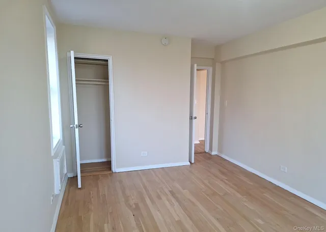 a view of an empty room with closet and a window