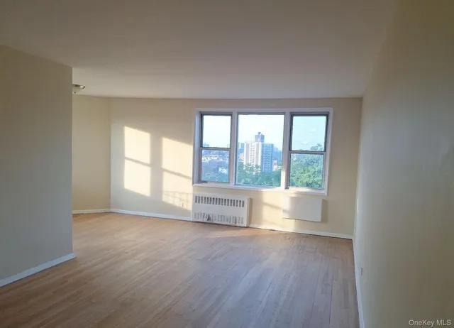 an empty room with wooden floor and glass door
