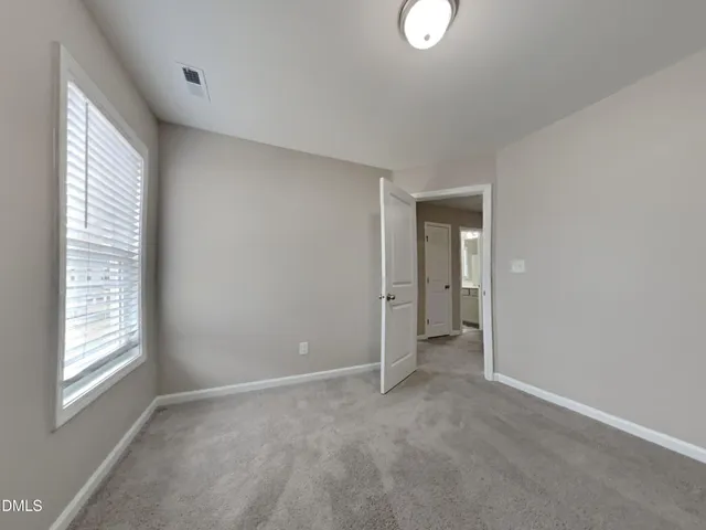 a view of an empty room with a window and closet
