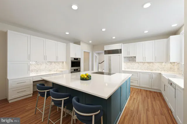 a living room with stainless steel appliances kitchen island hardwood floor and a view of kitchen