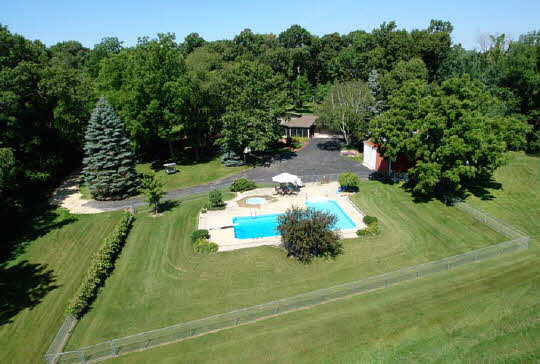 15925 Sharp Road Rockton, IL 61072 - Photo 1 of 6 a backyard of a house with table and chairs plants and large trees