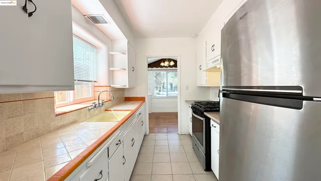 a kitchen with granite countertop stainless steel appliances a sink stove and refrigerator