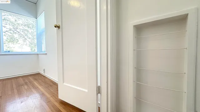 a view of a small space with wooden floor and a window