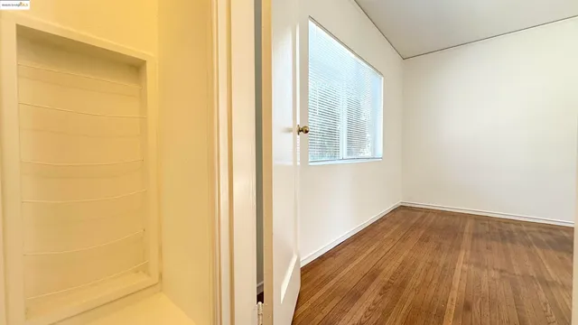 a view of a room with wooden floor and a window