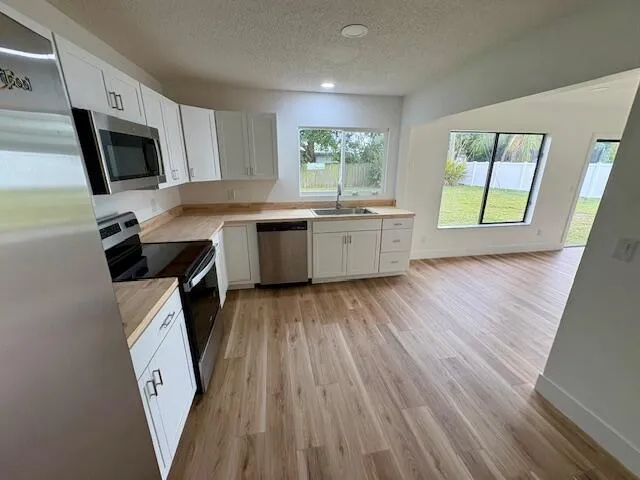 a kitchen with a sink a microwave a stove and refrigerator